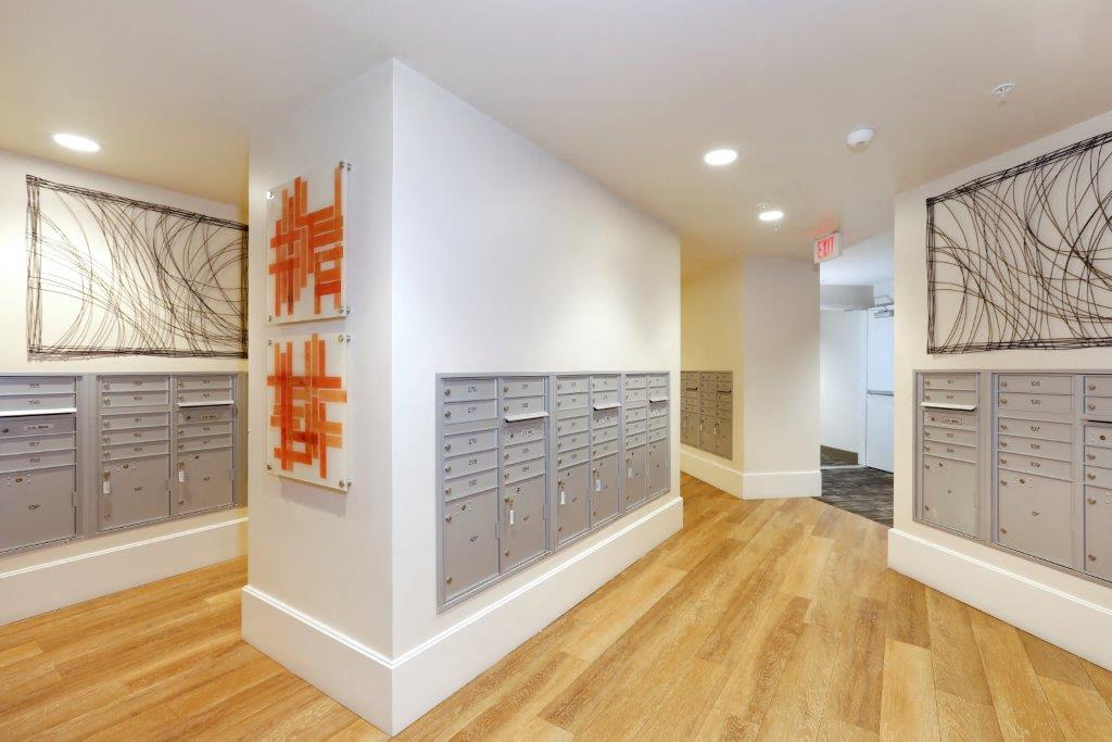 Mail room with a row of lockers and a painting on the wall.